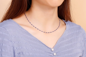 Detailed view of bohemian blue resin beaded necklace with silver titanium steel chain