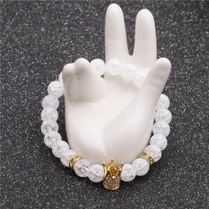8mm white cracked stone beaded bracelet featuring a gold crown charm on hand model