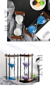 Detail of vintage wooden hourglasses with blue white and purple sand on a desk