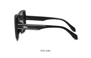 Detail view of black oversized sunglasses featuring a silver star inlay on the temples