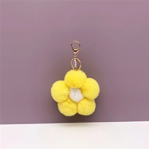 Detail of soft yellow and white plush flower bag charm with golden spring clasp link