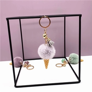 Detail von Plüsch-Eiscreme-Anhängern mit flauschigen Pelzkugeln und goldenen Kegeln