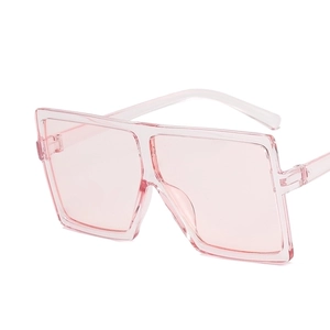 Detail view of pink translucent oversized square sunglasses with a 45-degree side angle