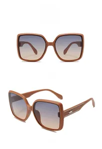 Detail of square sunglasses with brown frames and blue-to-tea gradient lenses