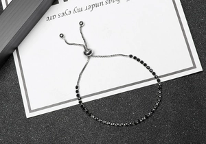 Detail of adjustable silver chain bracelet featuring a row of sparkling black rhinestones