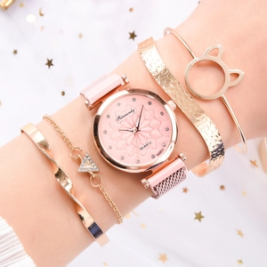 Close-up of rose gold watch set with pink dial and cat ear cuff on model wrist