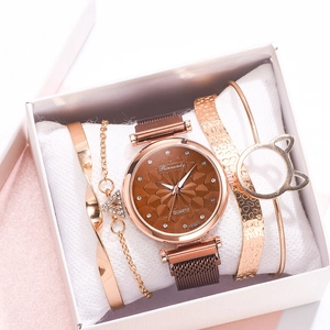 Detail view of rose gold quartz watch and cat-ear bracelets set in a white jewelry gift box