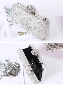 Detailed view of white beaded evening bag with floral metal clasp and black interior