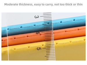 Close-up showing colorful notebook stitching details and thickness with a ruler scale