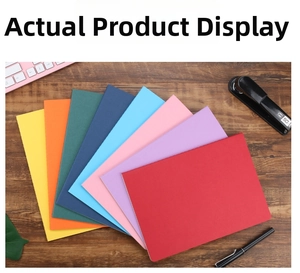 Flat lay of eight colorful A5 and A6 notebooks arranged in a fan shape on a wooden desk