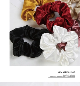 Dettaglio di elastici scrunchie in seta satinata con texture lucida e colori vivaci