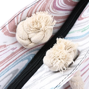 Printed canvas tote bag with beige cotton rope knots and black zipper closure detail