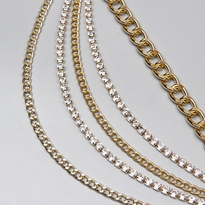 Détail de chaînes gourmettes dorées et rangées de strass brillants pour style hip-hop