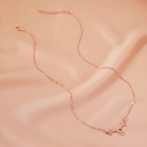 Detail of rose gold elk necklace with zircon antlers and pendant on champagne satin