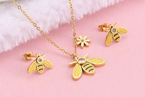 Macro detail of gold bee jewelry set with white zircon stones and yellow enamel finish