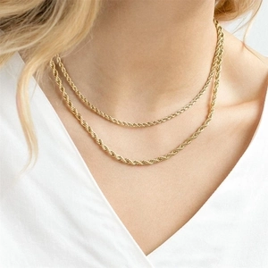 Close-up of a double-layered golden twist chain necklace on a model's neck