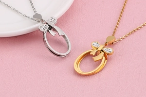 Detailed close-up of oval bow pendants with white rhinestones in gold and silver finish