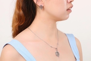 Detailed view of silver necklace and earrings set with crystal pavé circle charms
