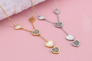 Detailed view of gold and silver Y-shaped necklaces with heart-shaped shell and diamond pendants
