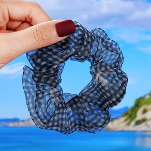 Detail of blue and black checkered organza scrunchie with soft pleats and airy texture