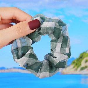 Detail shot of green and white plaid scrunchie in lightweight translucent chiffon fabric