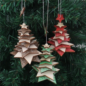 Close-up of three layered wooden star ornaments with bells hanging on a Christmas tree