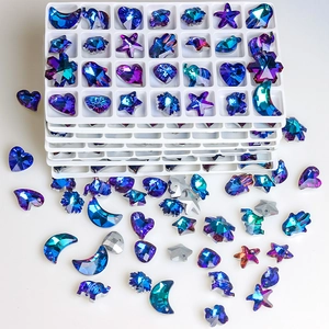 Macro shot of iridescent blue and purple star and heart shaped crystal DIY jewelry charms