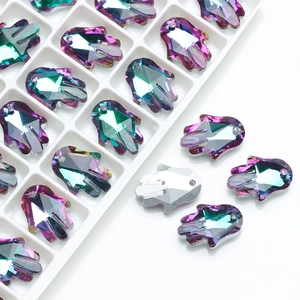 Detailed macro view of colorful Hamsa Hand crystal pendants in a white sorting tray
