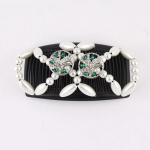 Detail of beaded magic hair comb with white pearls, green gems and floral metal accents