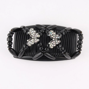 Detail of magic hair comb with black beads and crystal butterfly metal decorations