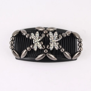 Macro detail of magic hair comb with grey beads and sparkling dragonfly rhinestones