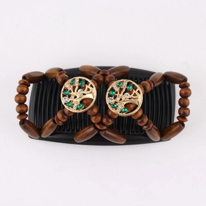 Detail of tree of life hair comb with brown wood beads, green gems and clear crystals