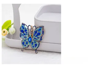 Close-up of blue crystal butterfly keychain with gold plating and hollow wing details