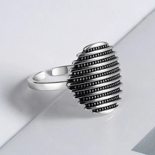 Macro detail of silver U-shaped textured ring with horizontal lines and dotted design