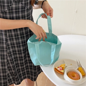 Detail of canvas lunch bag with magnetic clasp shown in a lifestyle daily setting