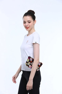 Close-up of hand-held skull pattern travel pouch with floral digital print details