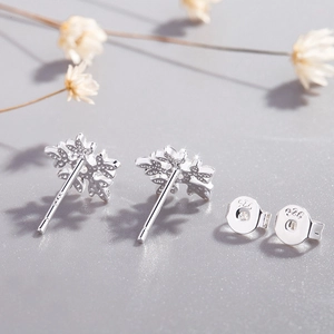 Elegant S925 sterling silver snowflake stud earrings displayed with decorative dried flowers