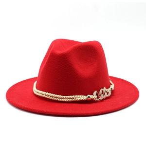 Détail du chapeau fedora rouge en laine avec double corde tressée dorée et chaîne métal