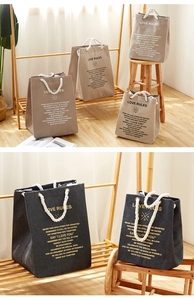 Detail of khaki and grey canvas storage bags with thick cotton rope handles and print