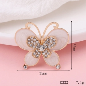 Detail view of 35mm gold butterfly charm with white enamel and sparkling rhinestones