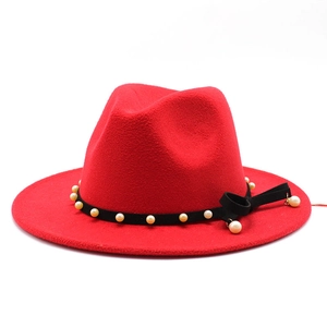Detail of red wool fedora with black velvet band, white pearls and side ribbon bow