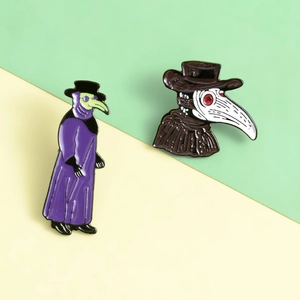 Detail view of two plague doctor enamel pins featuring purple robes and a white beak mask