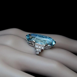 Detalle de anillo de plata con gran cristal azul ovalado y detalles de diamantes