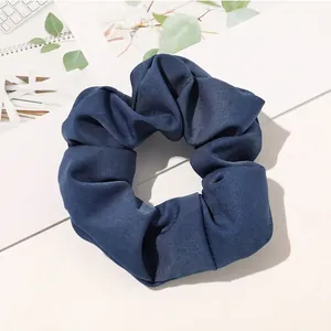 Detail shot of navy blue twill fabric scrunchie with natural pleated texture and soft finish