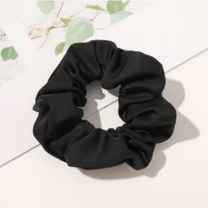 Detail of classic black twill fabric scrunchie hair tie for ponytail styling