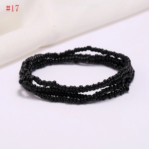 Detail of multi-layered black seed bead strand showing glossy resin texture and beads