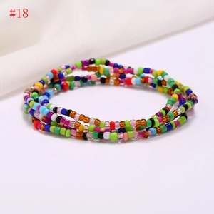 Detailed view of handmade colorful seed bead waist chains and multi-layered summer beach jewelry