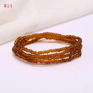 Detailed view of multilayer amber glass seed bead waist chain on white fabric background