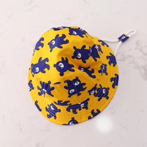 Detail of yellow kids bucket hat with navy bear print and adjustable white chin strap
