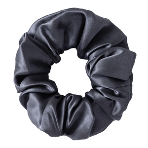 Detail of 3.5cm black mulberry silk scrunchie with elegant folds and natural sheen